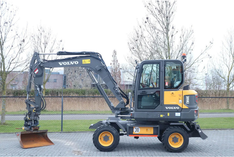 Volvo EW 60 E | DEMO | 30 KM/H | ROTOTILT + GRIPPER | BUCKET - Pelle sur pneus: photos 1 Volvo EW 60 E | DEMO | 30 KM/H | ROTOTILT + GRIPPER | BUCKET - Pelle sur pneus: photos 1