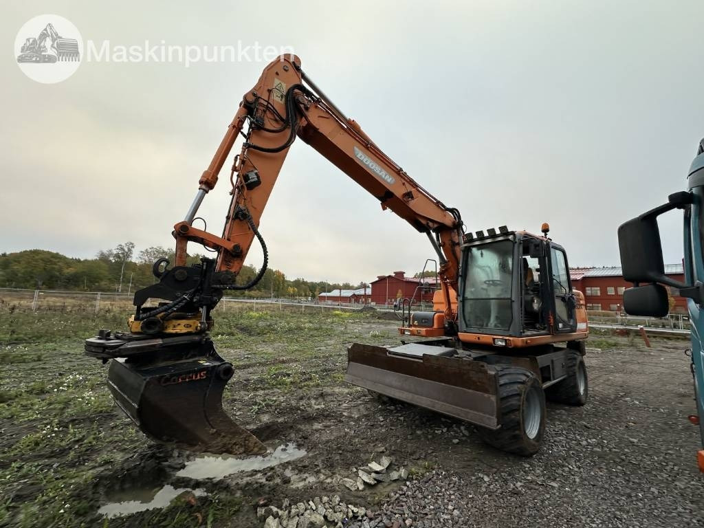 Doosan DX 140 W med vagn och redskap - Pelle sur pneus: photos 1 Doosan DX 140 W med vagn och redskap - Pelle sur pneus: photos 1